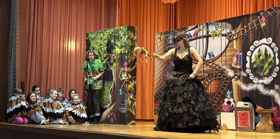 Foto von Papageno und Papagen sowie den Mitspielkindern auf der Bühne